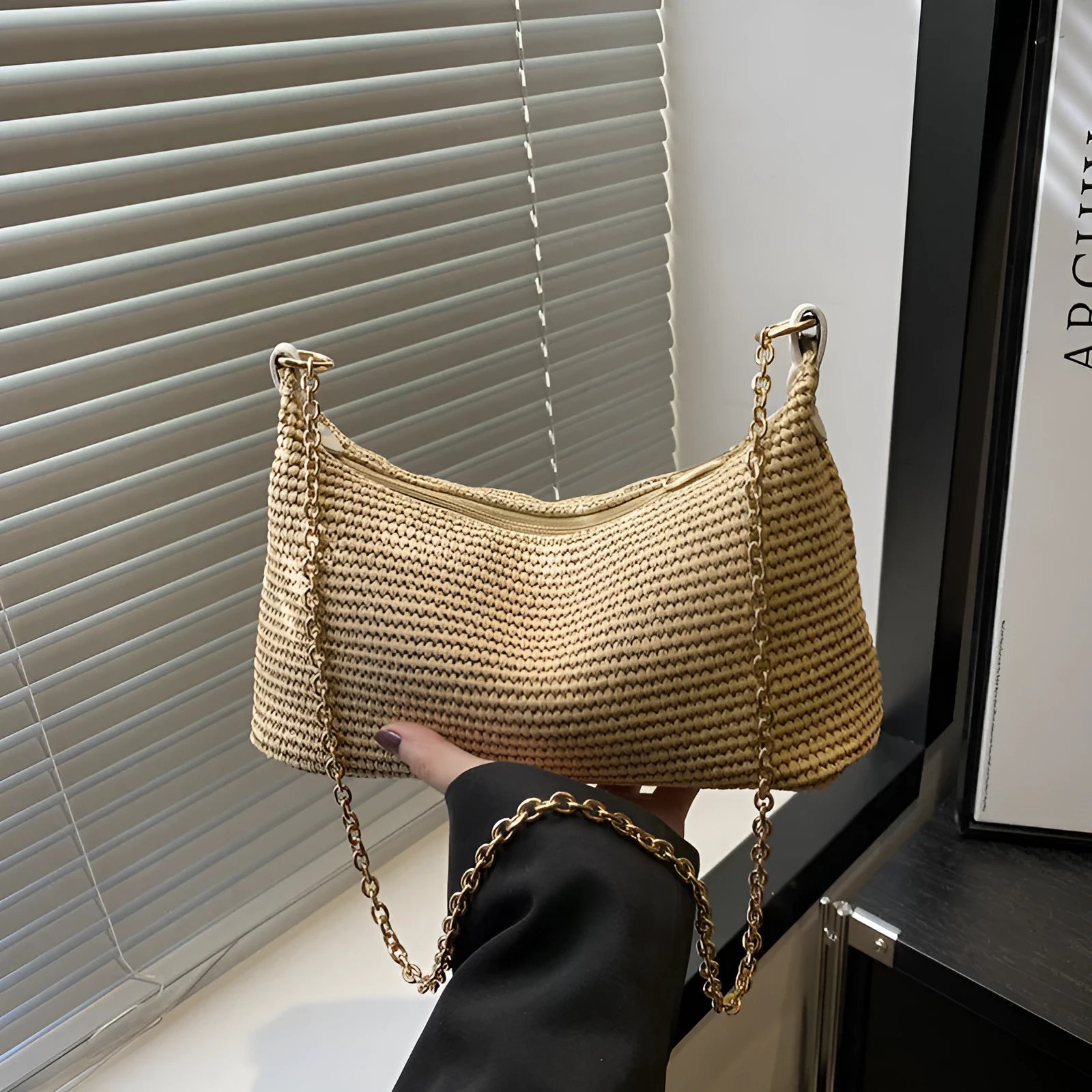 Khaki straw woven horizontal square tote bag with shoulder straps and outer sandwich pocket.