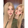 Long straight synthetic wig in milk tea blonde gold colour with hair net on display