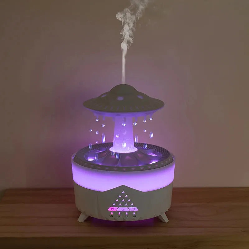White cloud-shaped humidifier with water droplets and coloured lights on wooden surface