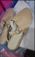 Women's black flat sandals with a buckle strap and pointed toe on a rubber sole.