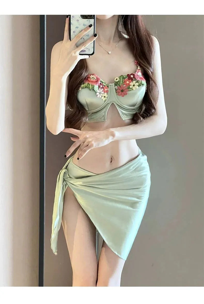 Green women's bikini three-piece set with triangle top, briefs, and matching skirt