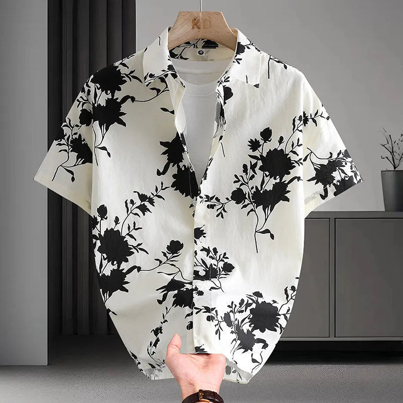Man wearing a short sleeve cotton Hawaiian shirt with a blue and white floral print.