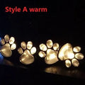 Black solar powered animal paw print garden lights with four paw shapes connected to solar panel