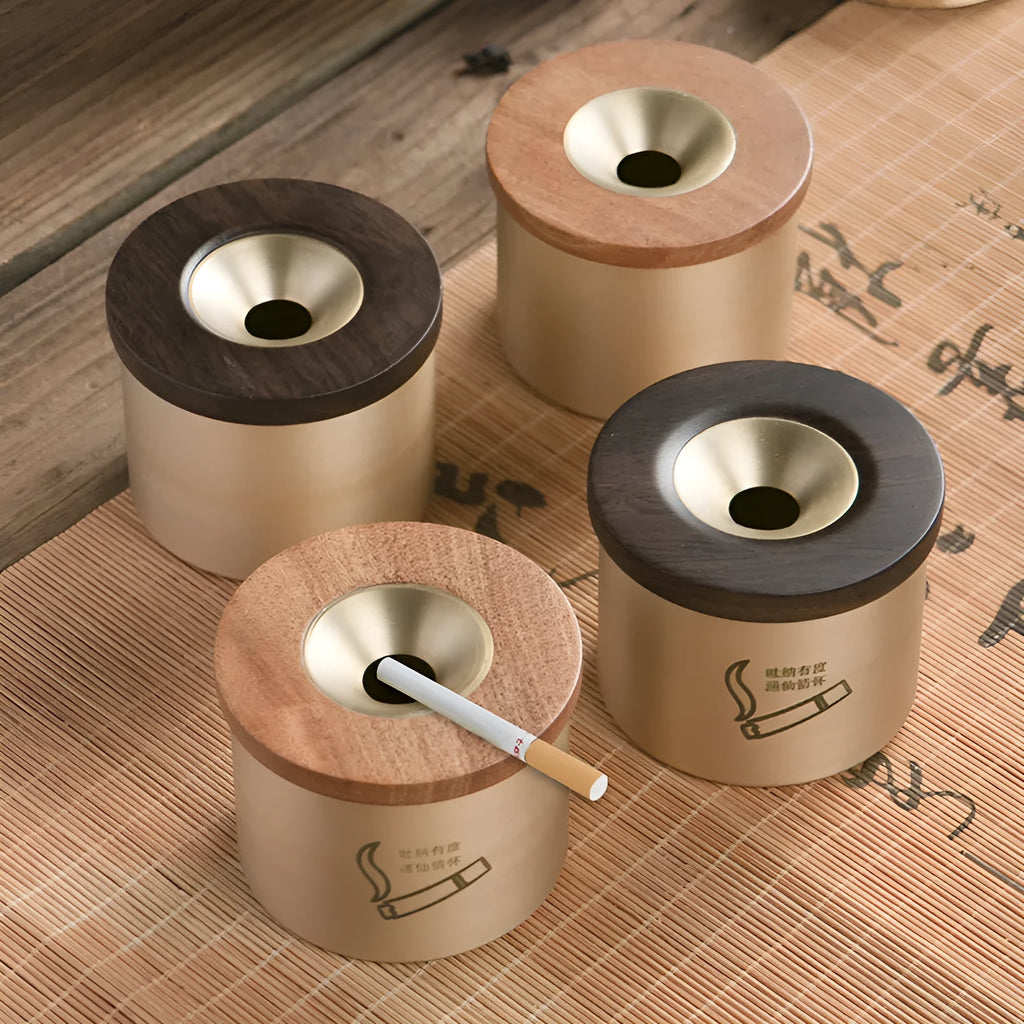 Brass-coloured copper ashtray with a wooden lid on a tabletop.