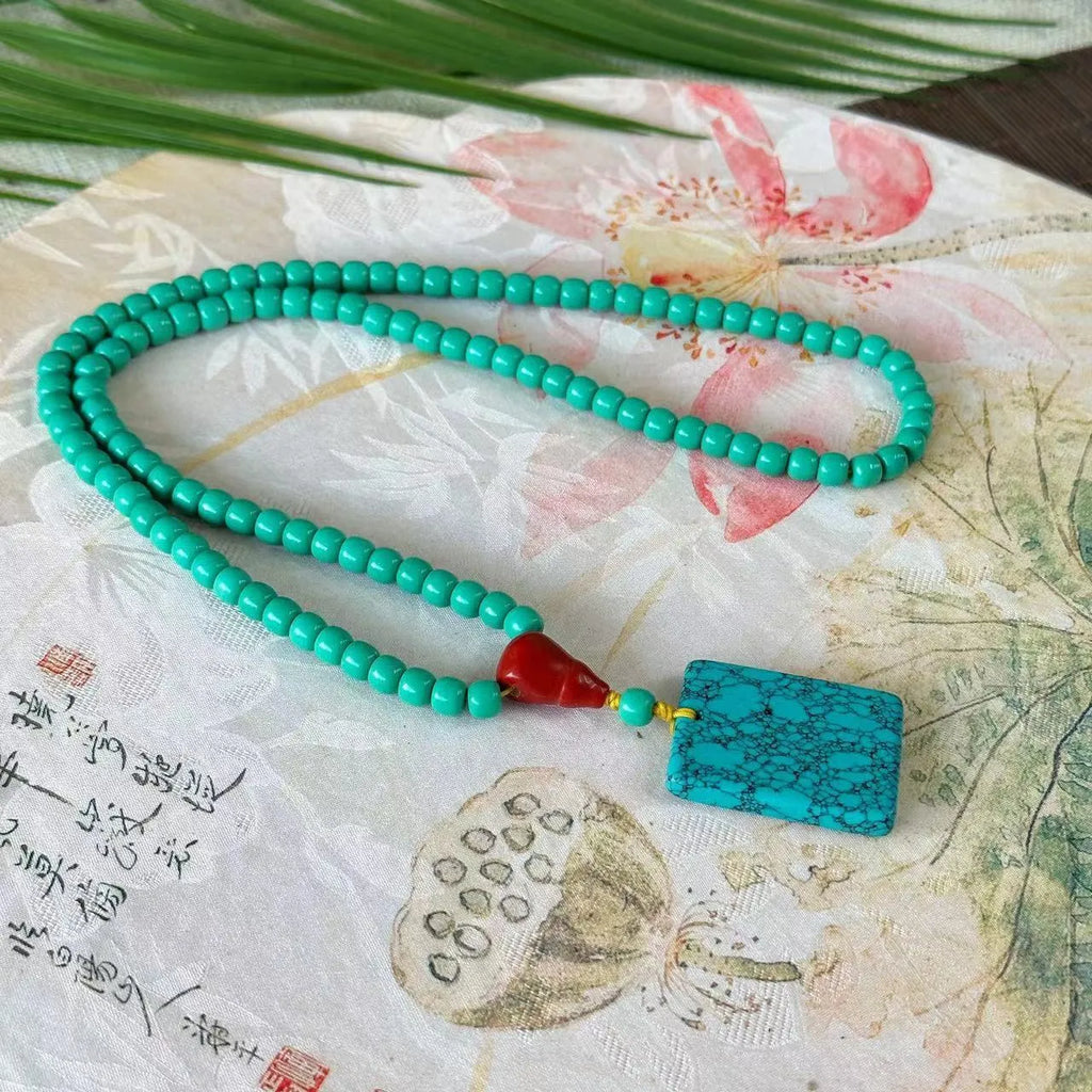 Hand-woven turquoise necklace with a large mesh flower lucky pendant on an adjustable ball bead chain.