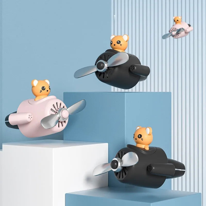 Cartoon small aeroplane shaped plastic car vent aromatherapy clip in black, blue, orange, or pink.