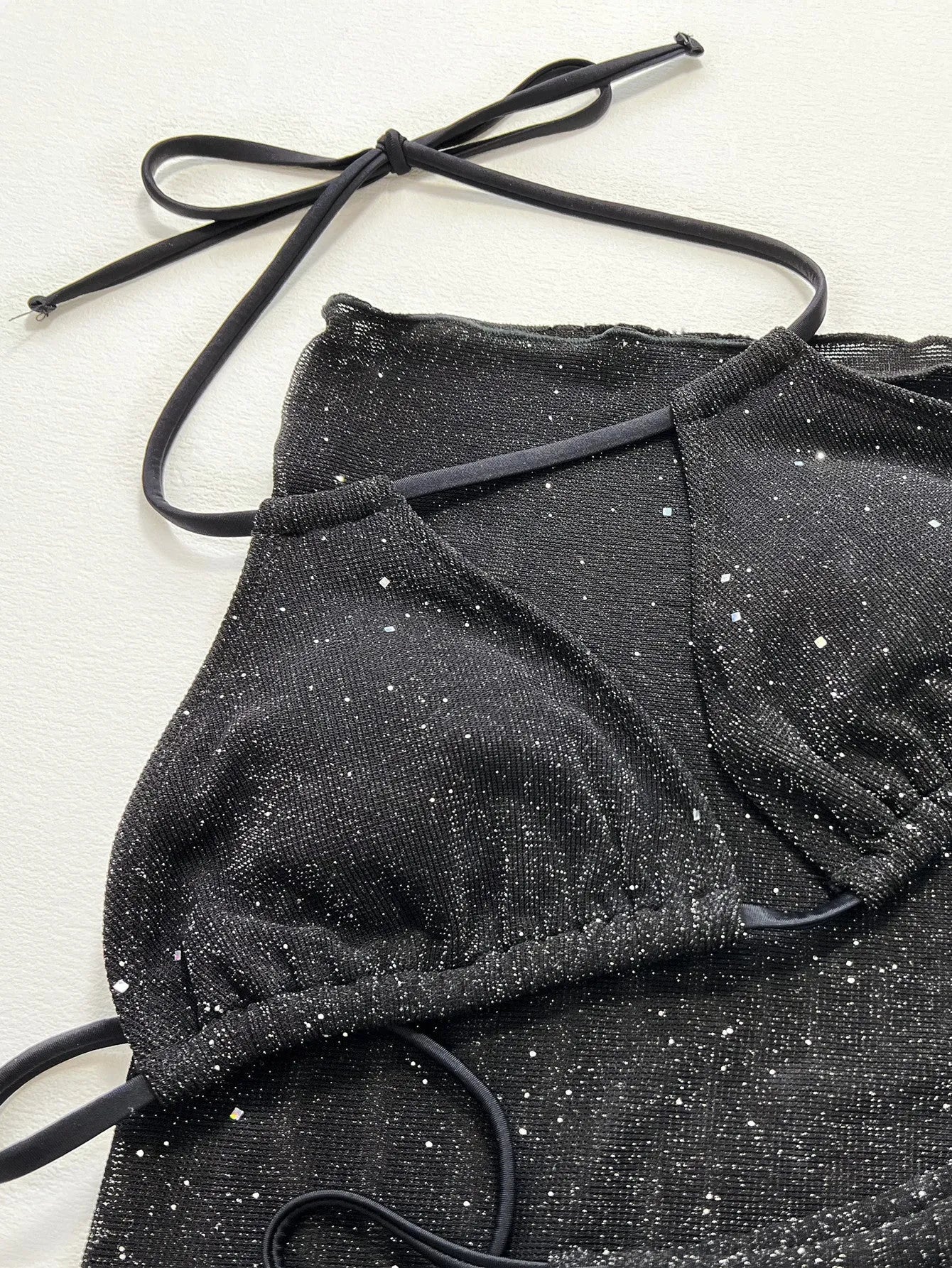 Black polyester fibre bikini set comprising a top and matching shorts on a mannequin.