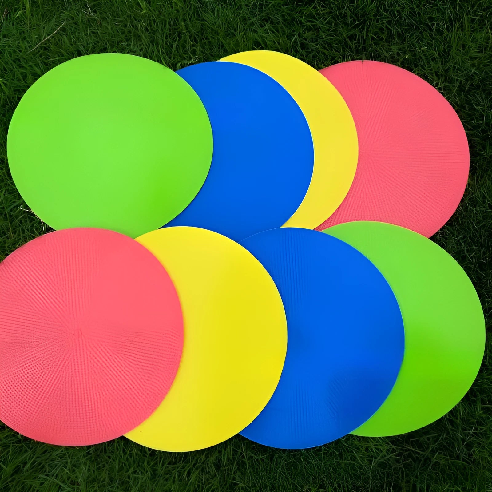 Yellow TPE football training landmark pad, 23cm diameter flat disc on grass.