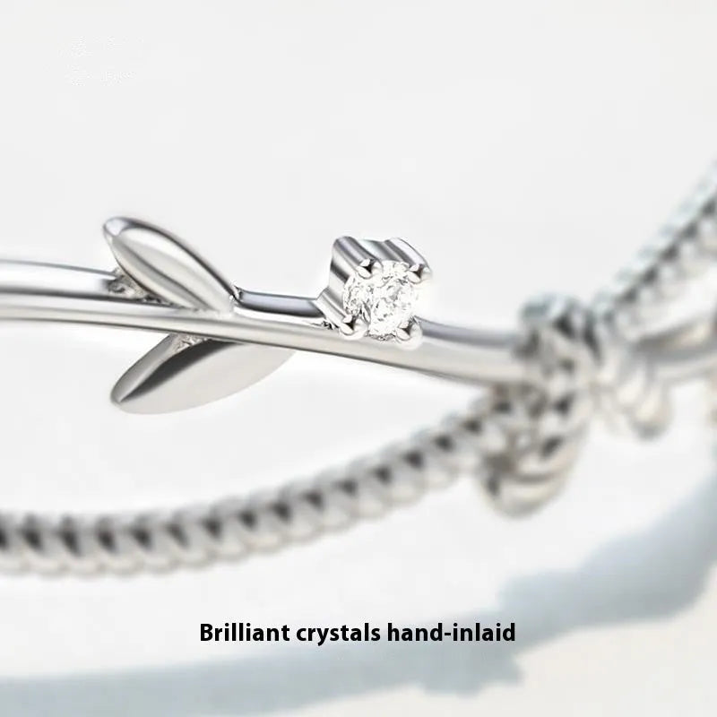 Cross twisted white gold electroplated bracelet with tree charm on copper base.