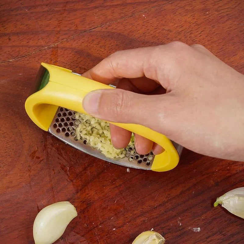 Stainless steel garlic press with ergonomic handle in available colours for kitchen use