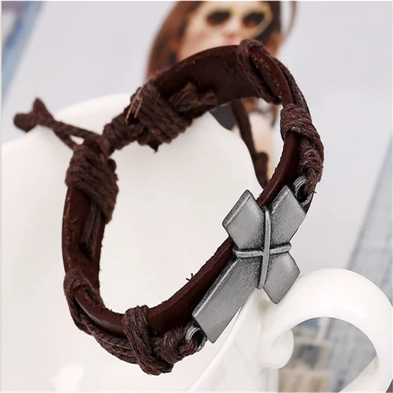 Brown leather cross bracelet with first layer cowhide and alloy accents on a neutral background