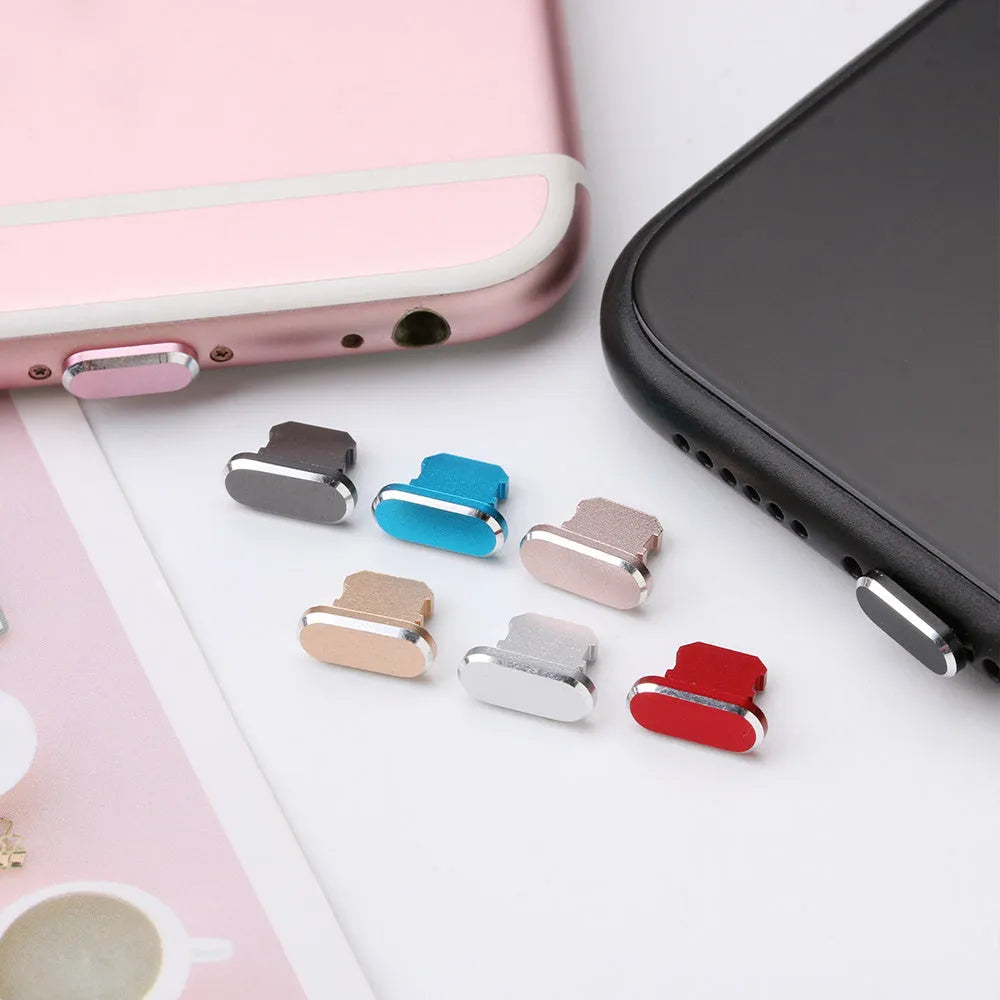 Aluminum alloy iPhone charging port dust plug in rose gold colour on a grey background.