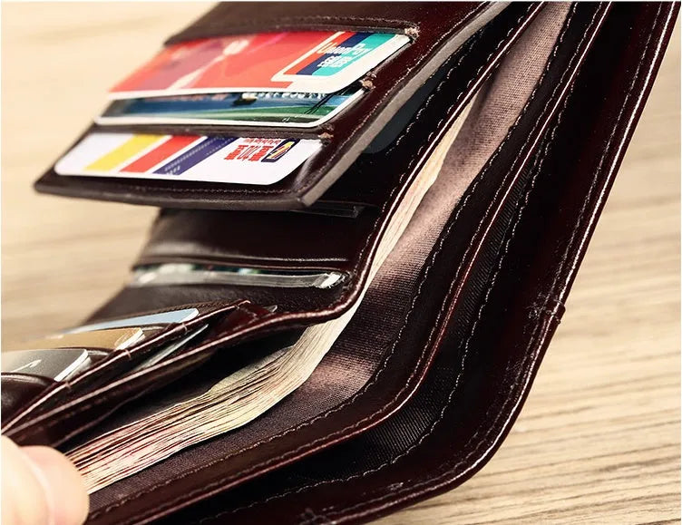 Men's black leather wallet open, showing internal card slots, photo slot, change pocket and hidden compartment.
