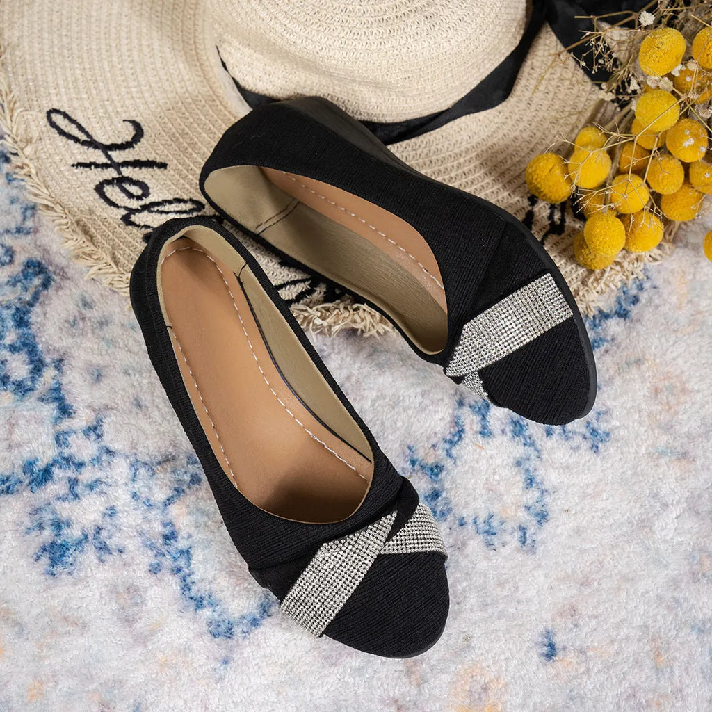 Women's black low-cut slip-on casual shoes with rhinestone detail and a short chunky heel.