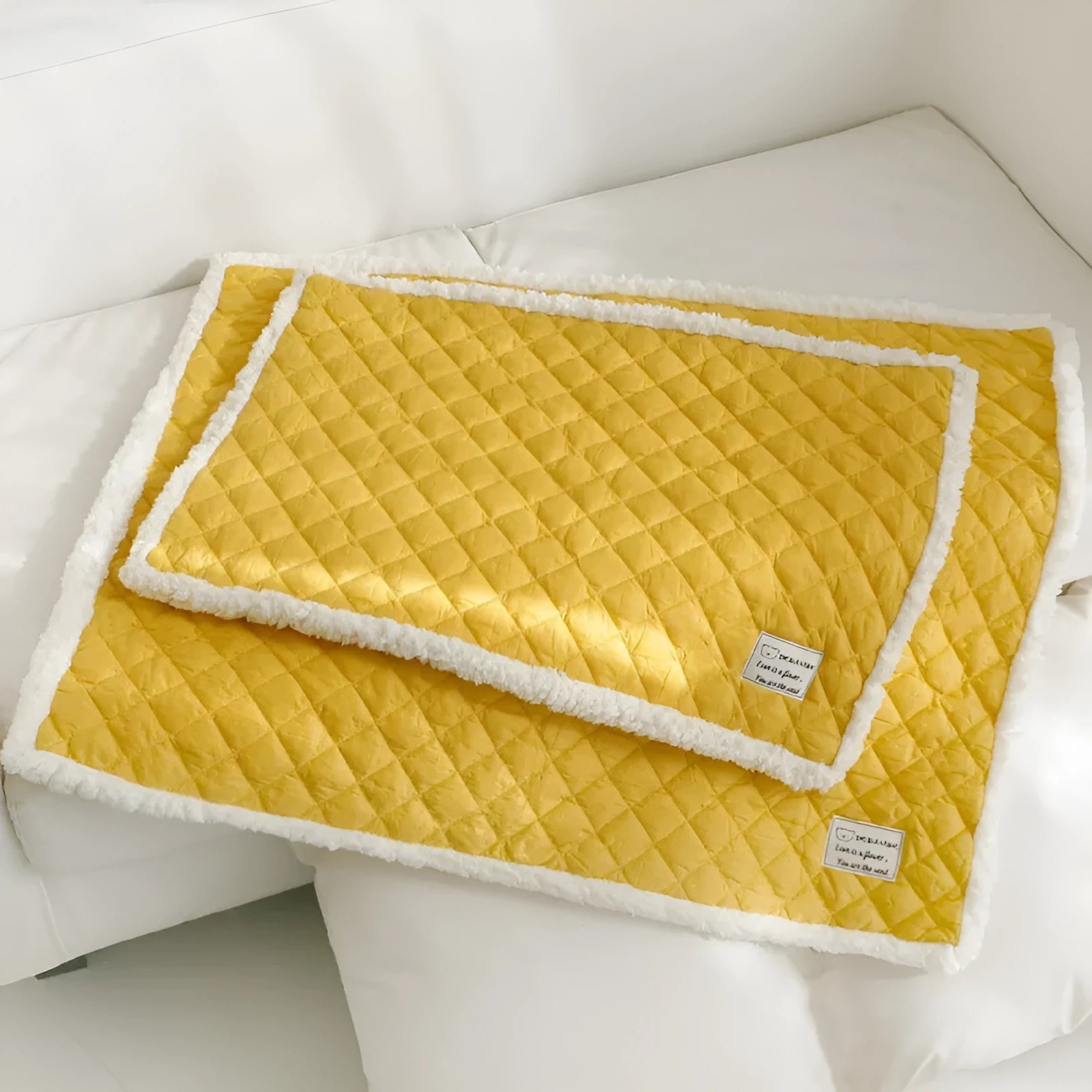 Quilted terry cloth cat blanket in blue, shown on a pet bed.