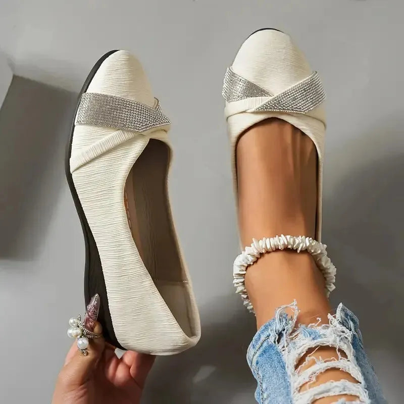 Women's black low-cut slip-on casual shoes with rhinestone detail and a short chunky heel.