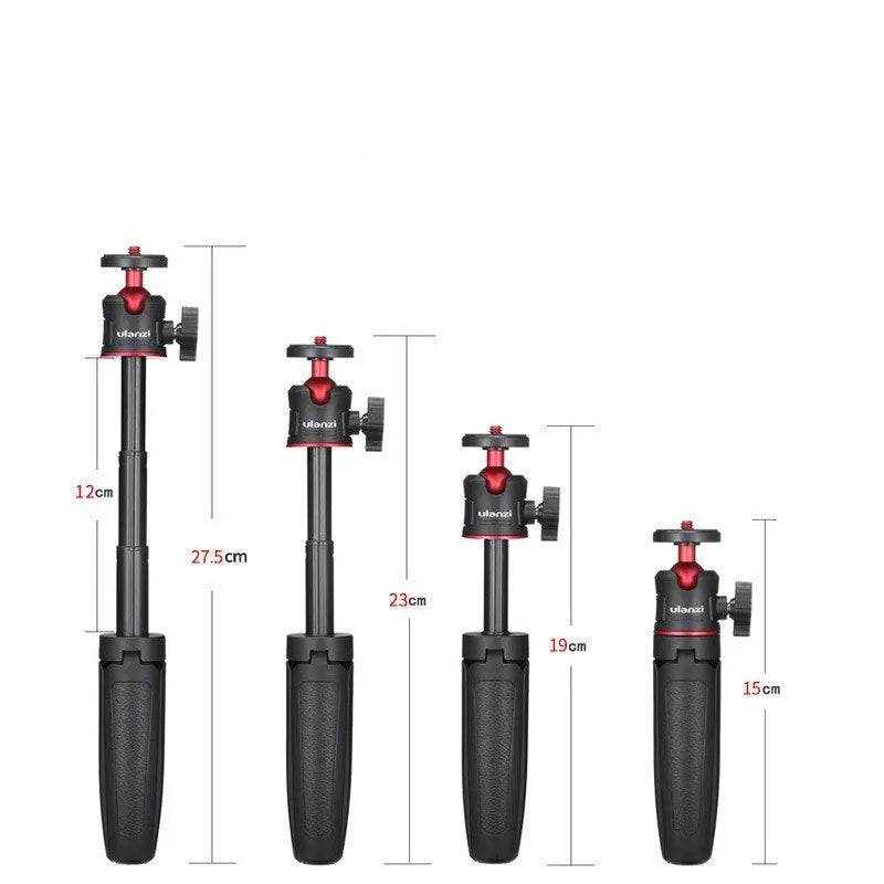 Black red and white aluminium mini tripod and extendable selfie stick for mobile phones on a desk.