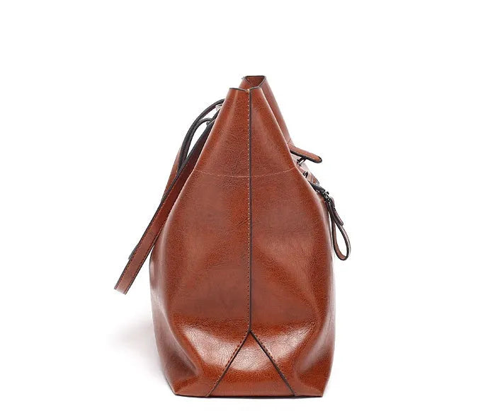 Brown leather cross-body handbag with a horizontal design showing two main compartments and a long strap.