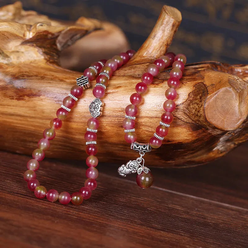 Handmade bracelet with geometric watermelon crystal beads and a Chinese knot closure.
