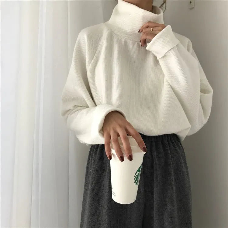Women's loose half-high collar long sleeve top in solid apricot colour on a hanger.
