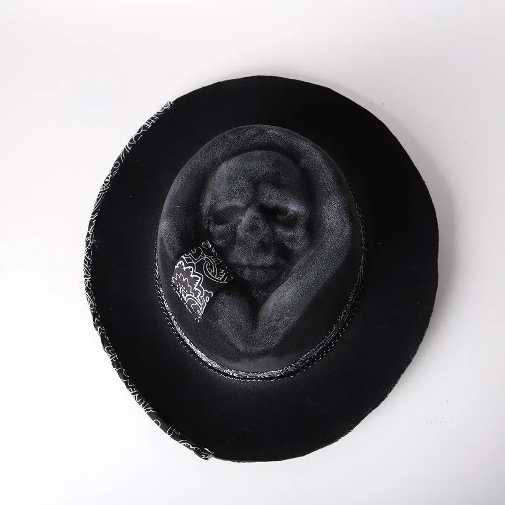 Handmade black and white skull print pointed witch hat on a wooden surface