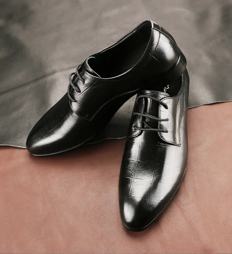 Men's black leather derby shoes with pointed toe and rubber sole on a white background.