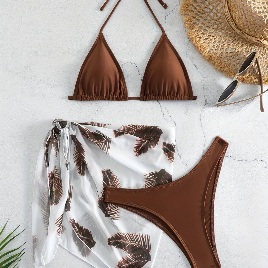 Orange three-piece swimsuit set showing bikini top, bottom, and a loose printed gauze skirt on a mannequin.
