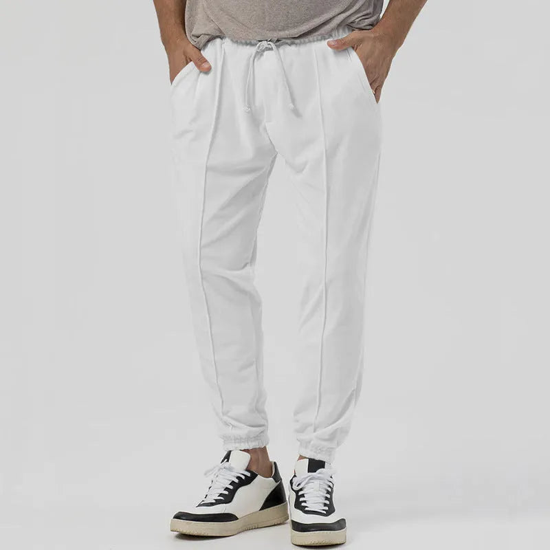 Men's grey loose tapered casual track sweatpants with a straight leg and elastic waistband.
