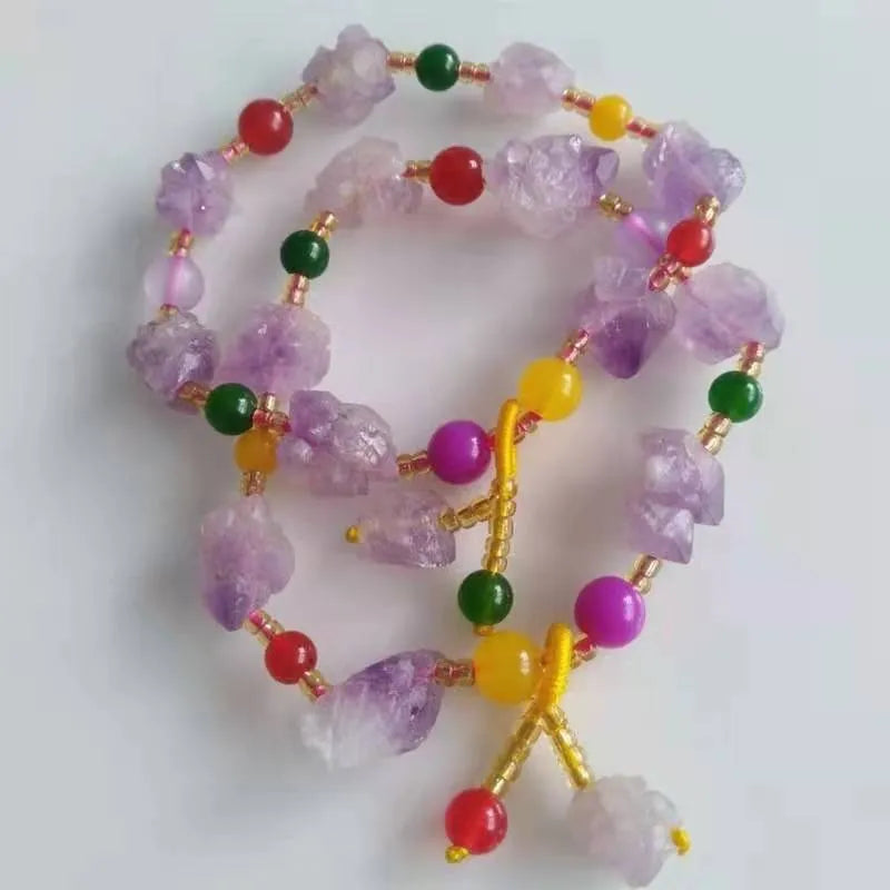 Purple amethyst bracelet with natural shaped beads and a fu character charm on a white background.