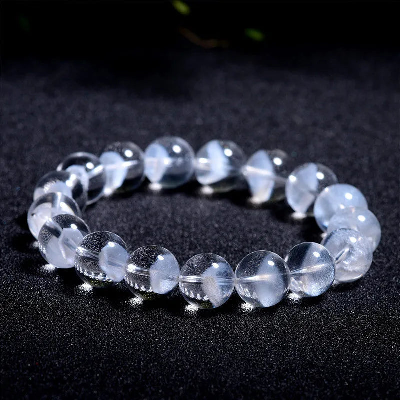 Women's white crystal pyramid bracelet with Ruyi symbol, showing polished beads.