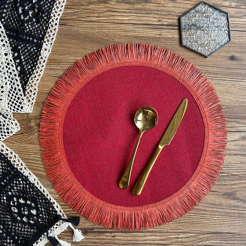 Handwoven round jute placemat with tassel edge in original hemp colour on a wooden table