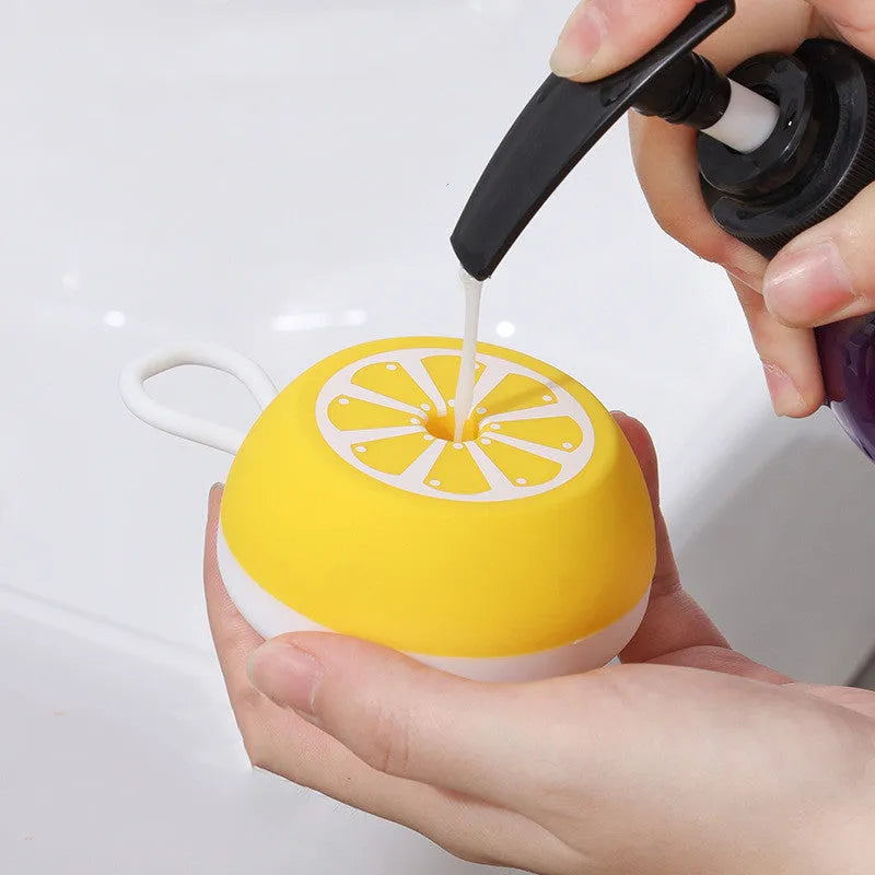 Yellow silicone pet bath brush with massage head on a blue background.