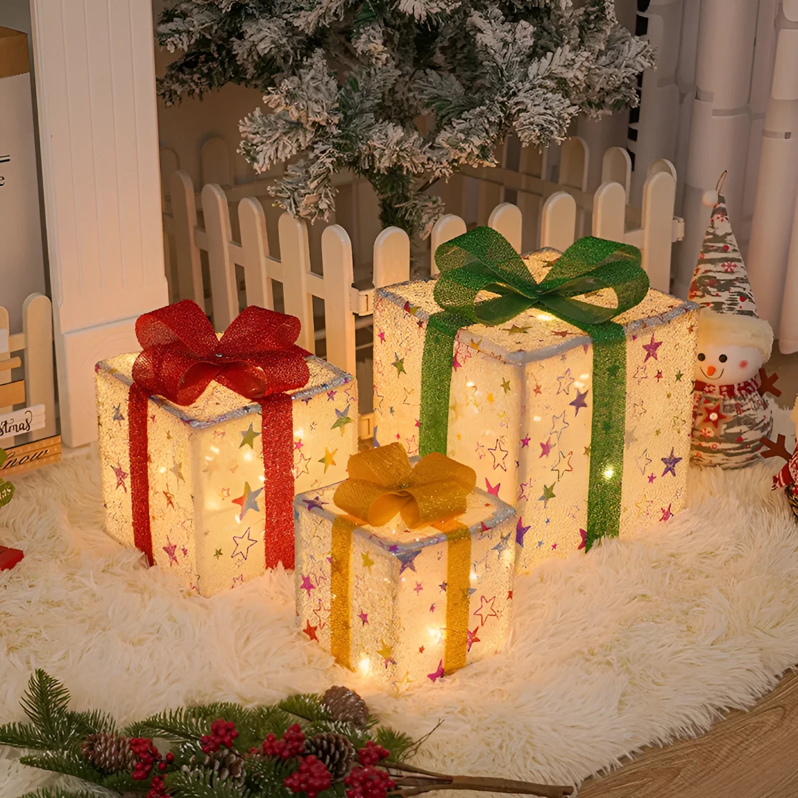 Set of three pre-lit Christmas gift box decorations with bows and LED lights for outdoor use.