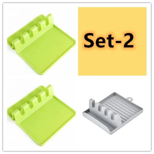 Green silicone kitchen utensil holder with four holes holding spatula, spoon, knife, and chopsticks on countertop