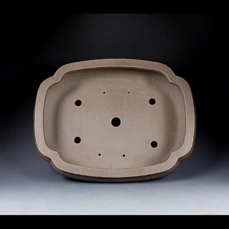 Handmade antique purple clay papaya-shaped flower pot on a table.