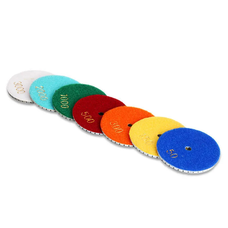 Set of 10 emery stone polishing discs with grits from 50 to 3000 mesh on a grey background.