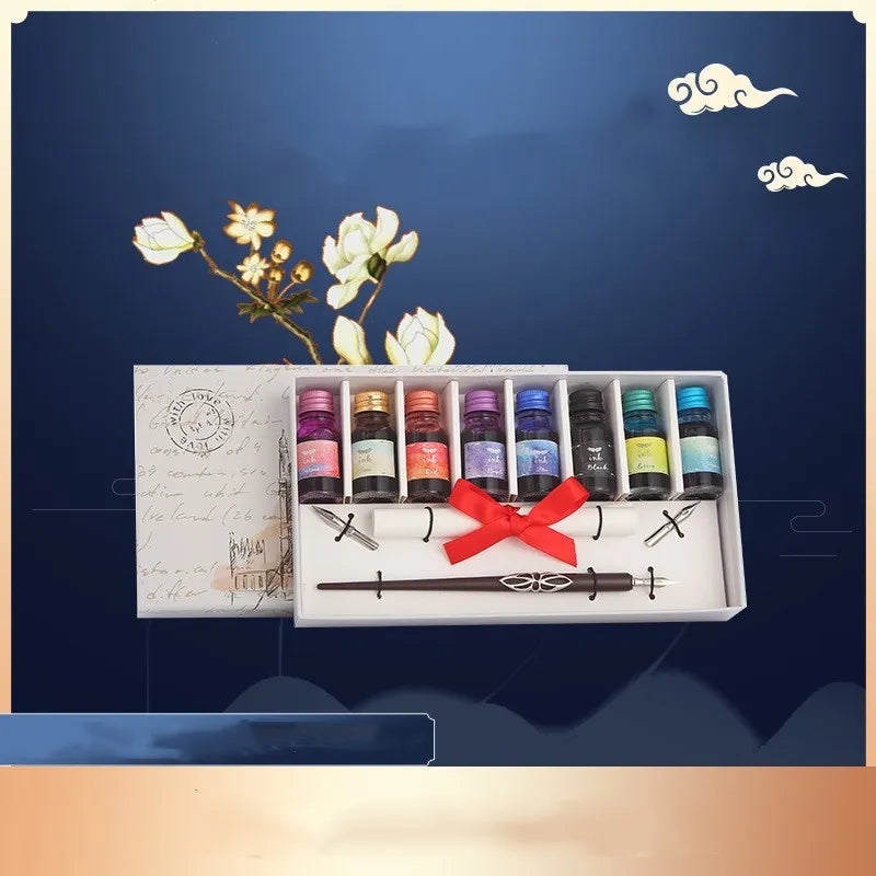Wooden dip pen, coloured ink bottles, and nibs arranged inside a wooden gift box for calligraphy.