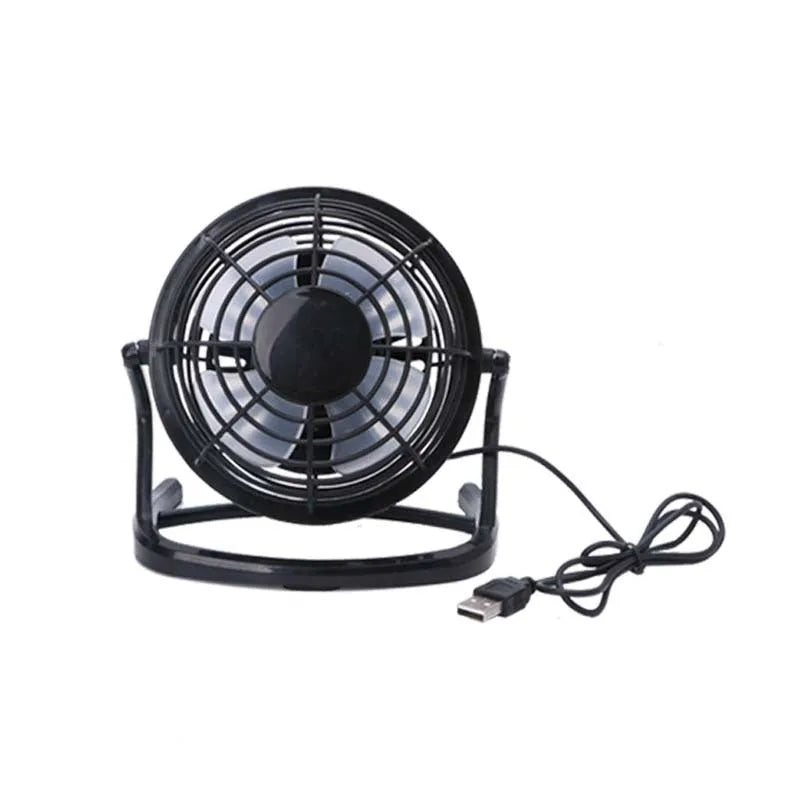 Black mini USB desk fan with adjustable angle on a wooden desk.