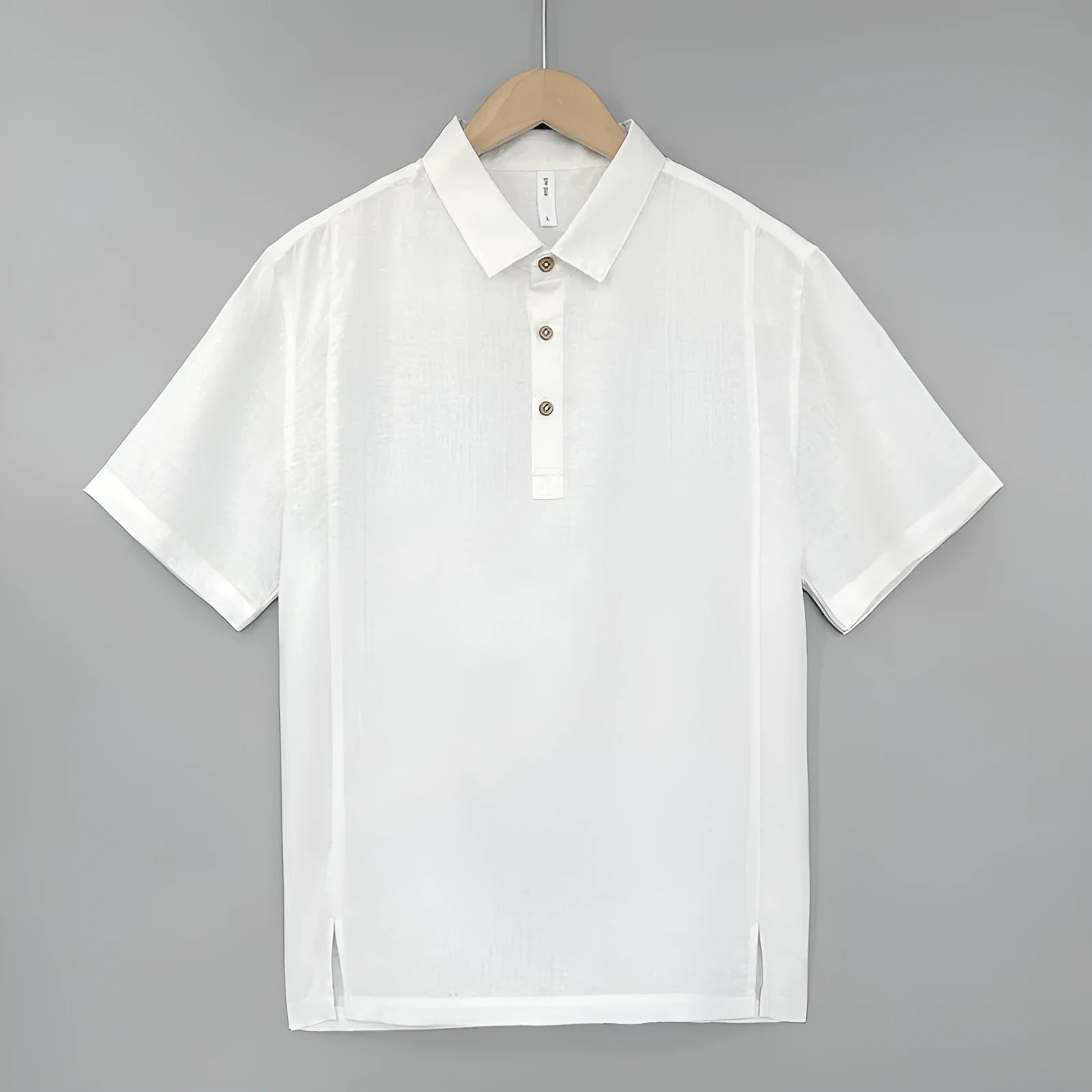 A man's loose-fit linen short-sleeve top in grey green with a V-neck and thin lapels, laid flat.