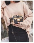 Hard black PU leather women's crossbody flap bag with metal rivet detail and hasp closure.