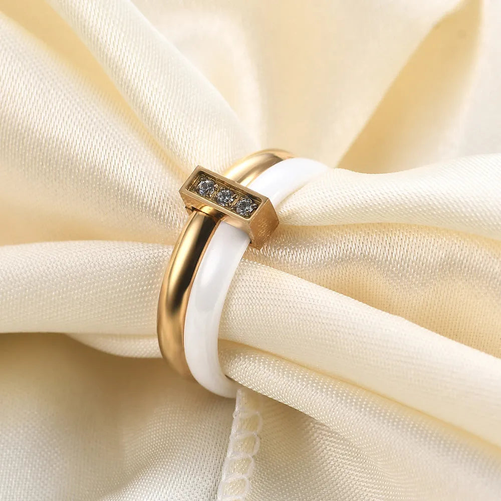 Glossy black ceramic women's ring with geometric shape and inlaid zirconium details on a finger.