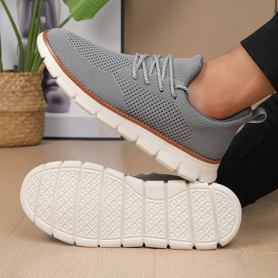 Men's grey and black low-top casual sneakers with woven mesh fabric upper and round toe.