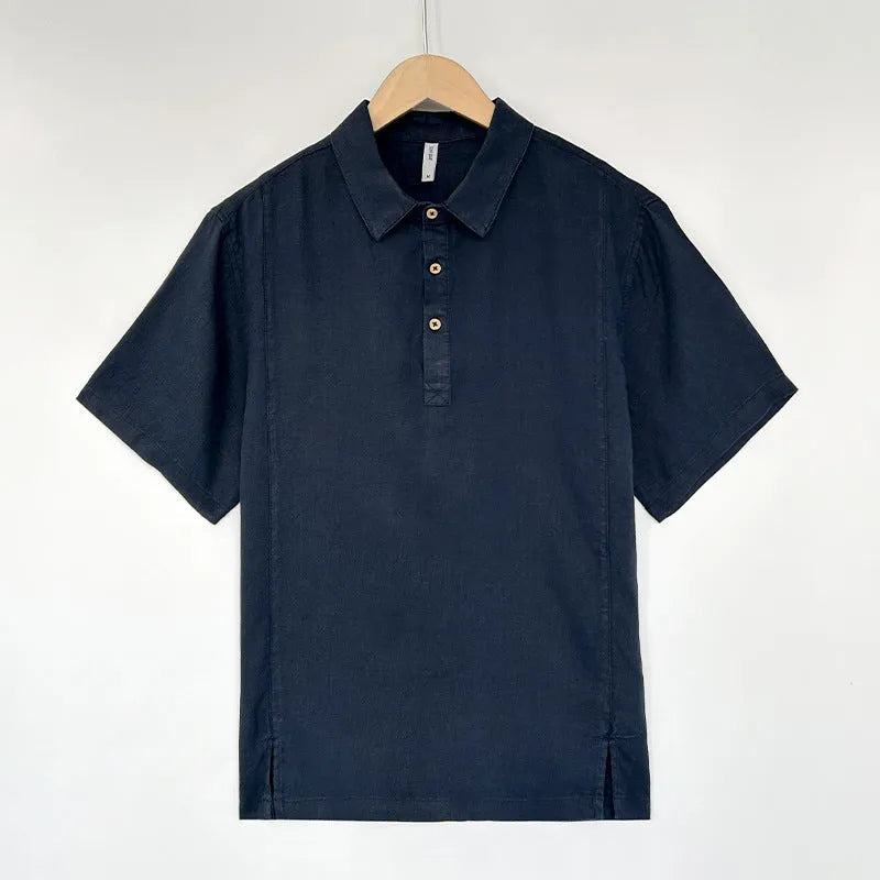 A man's loose-fit linen short-sleeve top in grey green with a V-neck and thin lapels, laid flat.