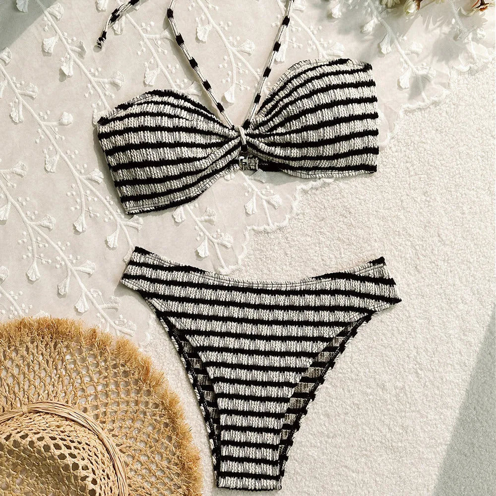 Women's pink and black striped printed bikini swimsuit on a hanger.