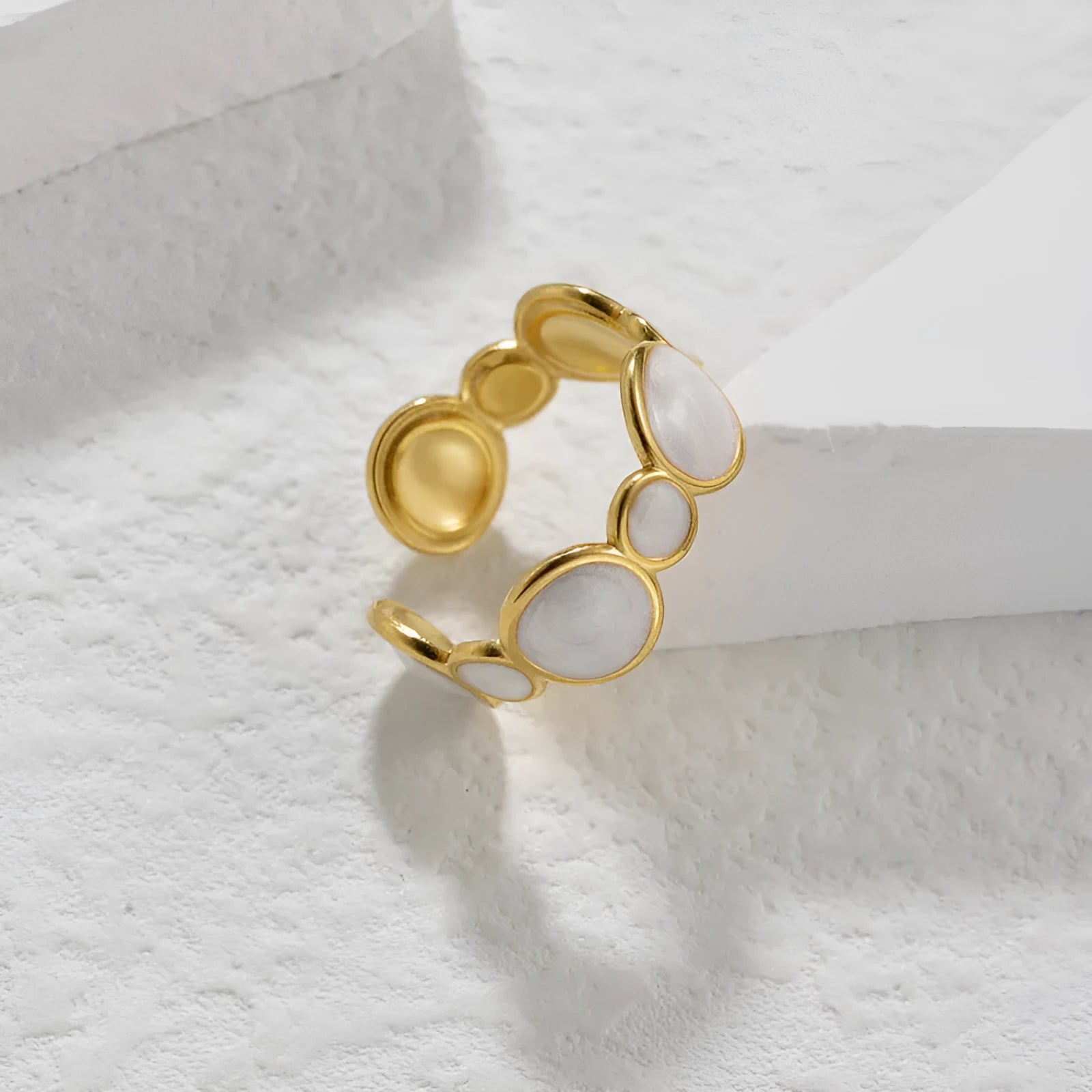 Adjustable stainless steel ring with a geometric shape and electroplated metallic finish.
