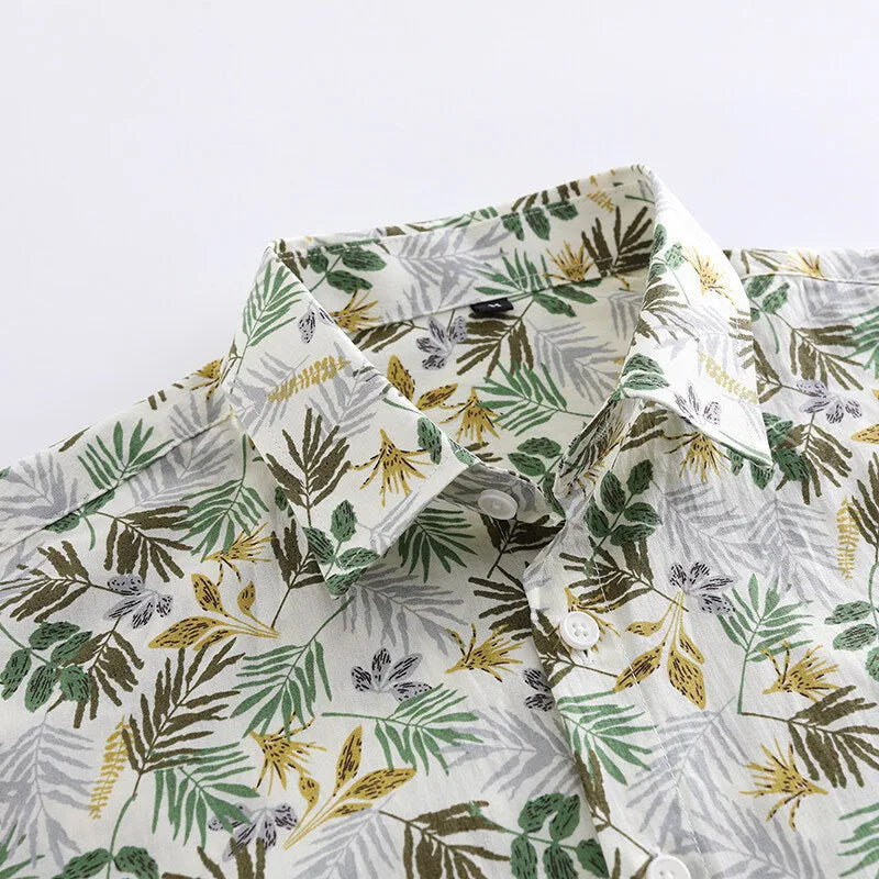 Man wearing a short sleeve cotton Hawaiian shirt with a blue and white floral print.