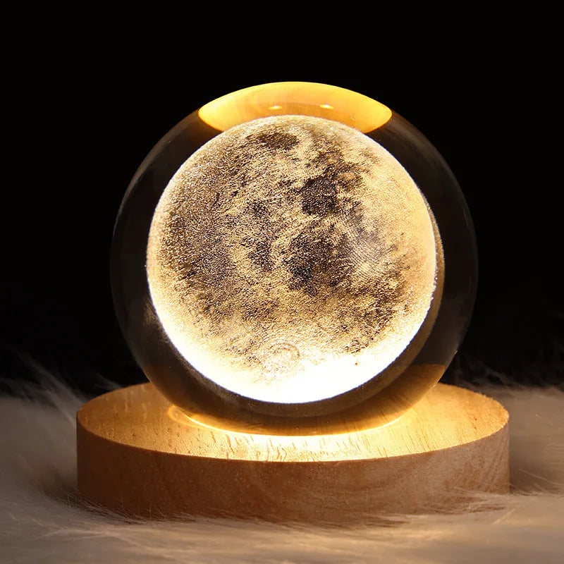 LED galaxy crystal ball night light with 3D planet designs on a table