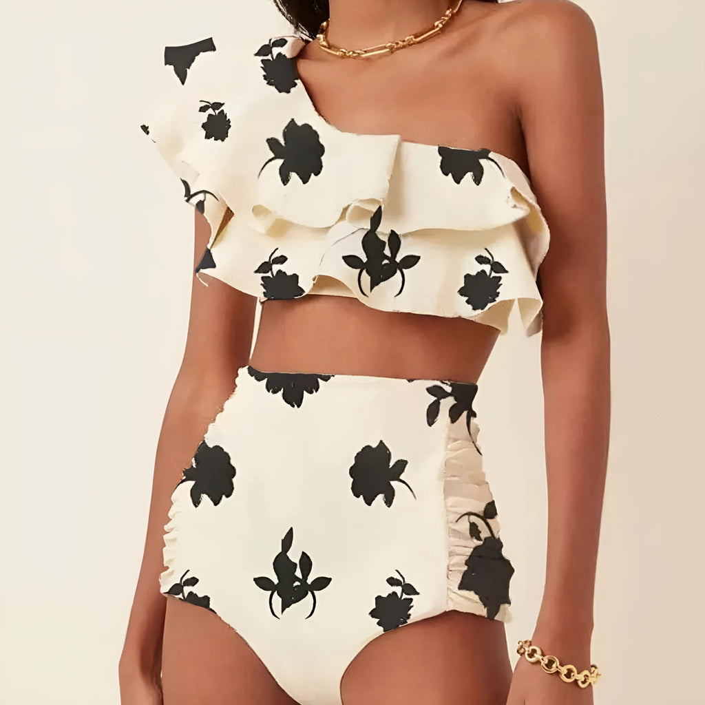 Women's beige bikini suit with ruffled oblique shoulder top and high-waist briefs on a mannequin.