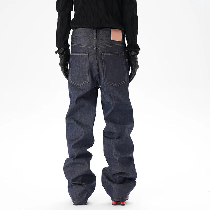 A pair of dark blue loose straight-cut jeans laid flat, showing the front design.