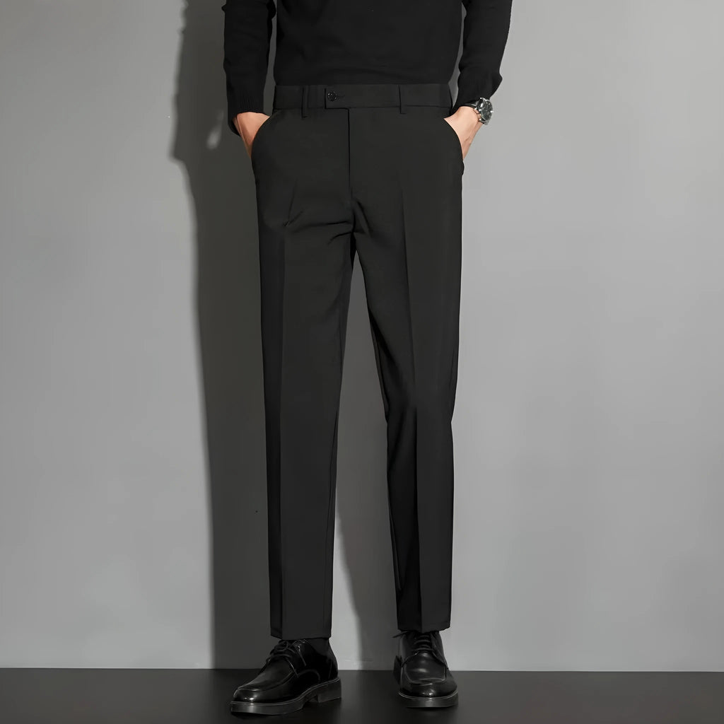 Men's straight-leg ankle-length suit trousers in a light colour showing spring draping effect detail.